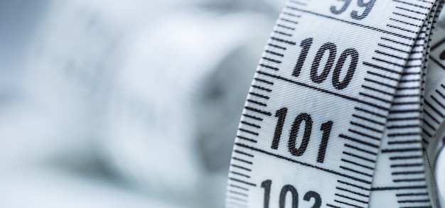 Curved measuring tape. Measuring tape of the tailor. Closeup view of white measuring tape.