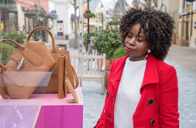 curvy african american woman walks on standing on the shopping street and looks                                   person