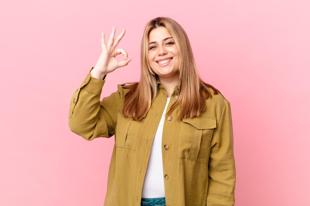 Curvy pretty blonde woman feeling happy, showing approval with okay gesture