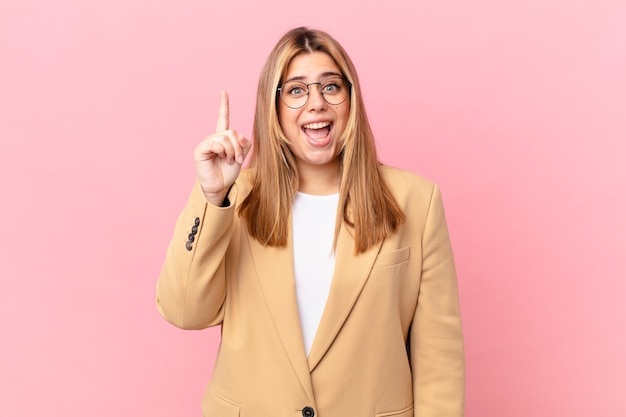 Curvy pretty blonde woman feeling like a happy and excited genius after realizing an idea