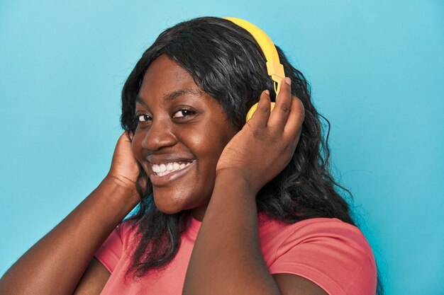 Curvy woman enjoying music with phone and headphones