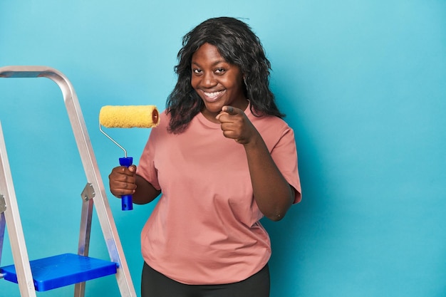 Curvy woman with paint roller and ladder having an idea inspiration concept