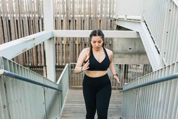 Curvy young woman running up the stairs outdoors