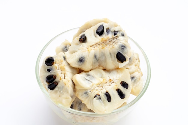 Custard apple in glass bowl on yellow background.