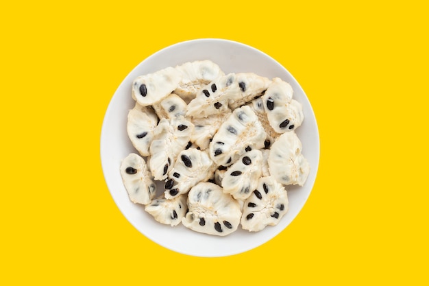 Photo custard apple in white plate on yellow background.