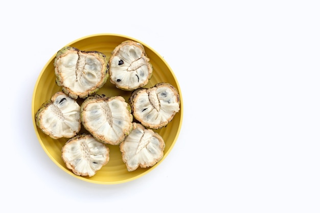 Photo custard apple in yellow plate on white background.