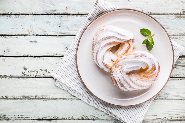 Foto anelli di torte alla crema o alla ricotta su una vista dall'alto di un piatto bianco