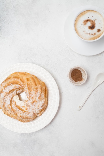 Custardcake eclair met koffie en hortensia's op grijze achtergrond