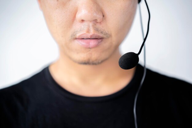Customer call center service care digital technology connect with work concept New gen leadership look Young business asian man using headphone for support White background