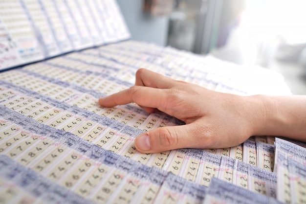 Photo customer choosing thai national lottery ticket.