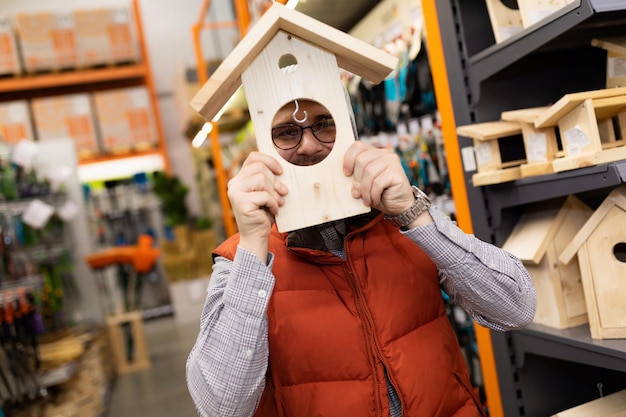 Customer in garden supply store fooling around with birdhouse