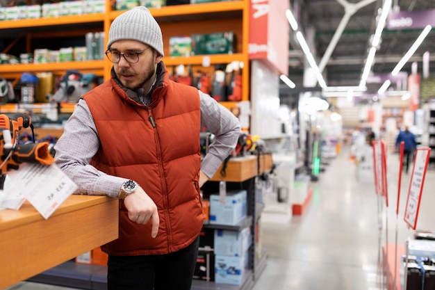 A customer in a hardware store inspects a counter with goods