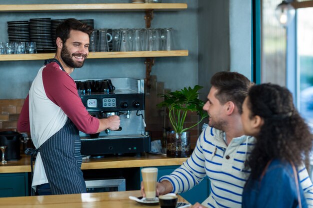 Customer interacting with waiter in coffee shop