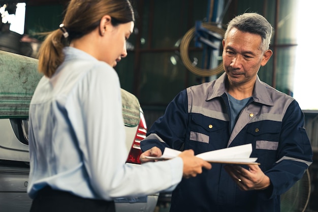 Foto cliente che effettua un controllo di ispezione su un lavoro di occupazione di riparazione del motore di un'auto presso l'officina della persona del tecnico del meccanico di servizio del garage al termine del trasporto di manutenzione automatica del veicolo dell'industria automobilistica