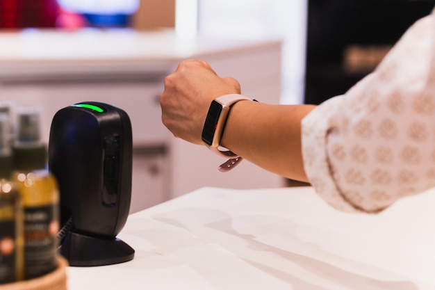 Photo customer making wireless payment using smartwatch at shopping store