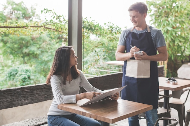 Cliente che ordina cibo verso la cameriera al bar