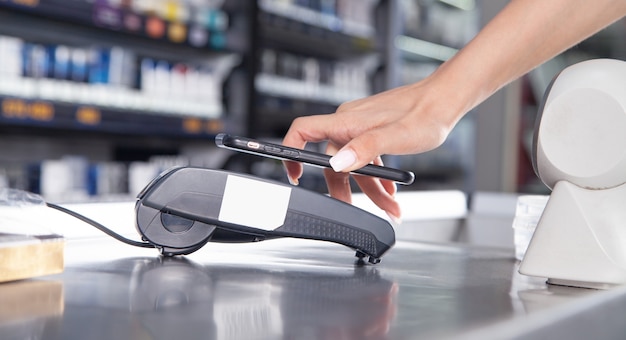 Customer paying for purchases contactless with smartphone.