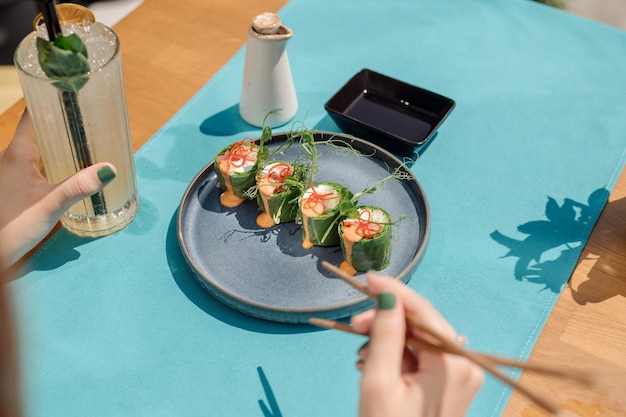 Customer of the restaurant is eating a sushi rolls Close up