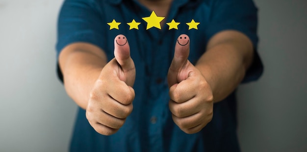Foto concetto di soddisfazione del cliente pollice in su icona faccina sorridente valutazione 5 stelle concetto positivo positivo