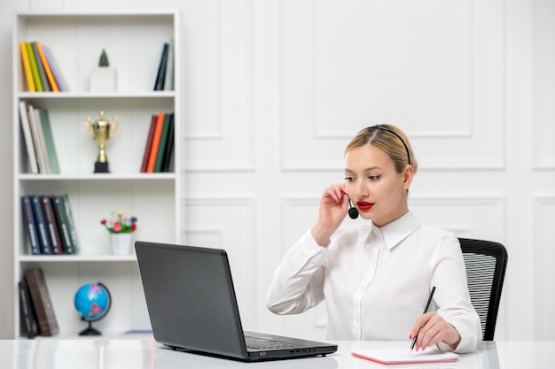 Customer service cute blonde girl office shirt with headset and computer talking to a client