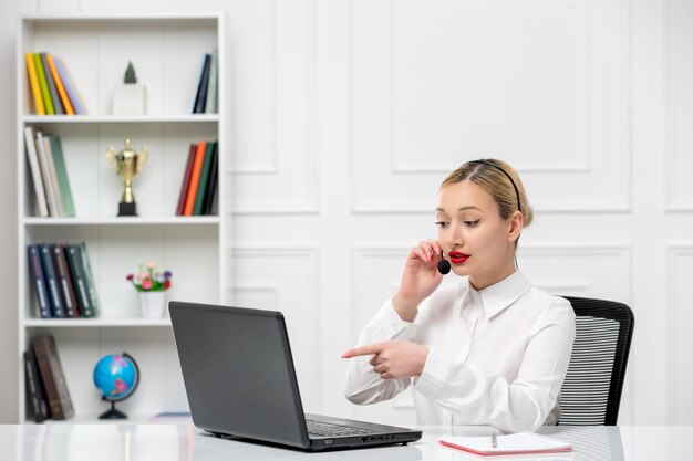 Customer service cute blonde girl office shirt with headset and computer talking to a client