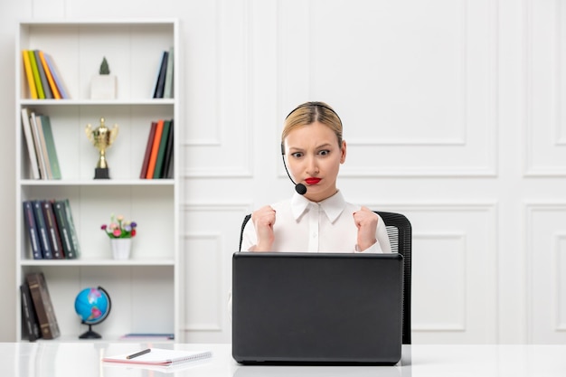 Customer service cute woman in white shirt with headset and computer angry holding fists