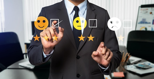 顧客サービス評価の概念 現代のオフィスのタブレットとスマートフォンで仮想画面に顔を押すビジネスマンの笑顔の絵文字ショーxA