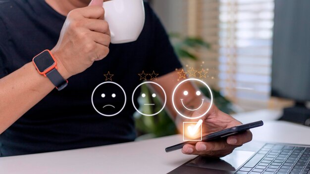 customer service evaluation concept using a smartphone is pressing face emoticon smiling in satisfaction on virtual touch screen