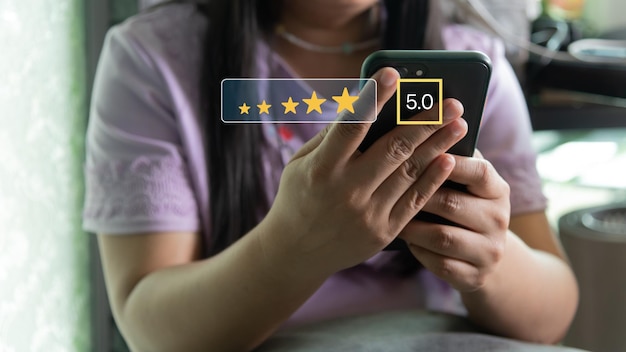 Foto customer service tevredenheid evaluatie concept man met behulp van smartphone en aanraking op het scherm met goud vijf sterren rating uitstekende feedback icoon beoordeeld een zeer goede recensie