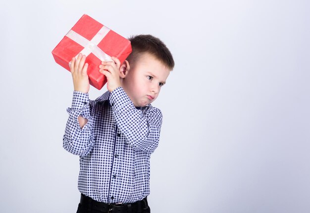 Customer. Shopping. Boxing day. New year. little boy with valentines day gift. shop assistant. Happy childhood. happy child with present box. Christmas. Birthday party. serious customer. copy space.