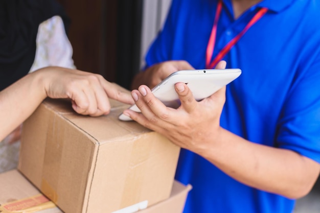 Customer sign on tablet while receiving package from deliveryman