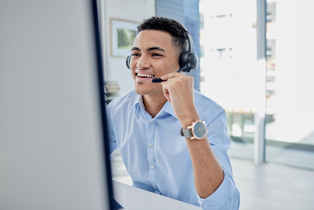 Customer support call center and male agent in the office doing an online consultation Contact us crm and professional young man telemarketing consultant on a call with a headset in the workplace