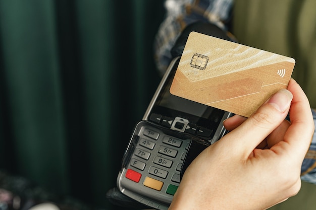 Customer using credit card for payment at cafe or shop by terminal with nfc cashless technology