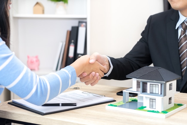 고객 또는 여성은 새로운 주택 개념을 구매하기 위해 대출 계약에 서명한다고 대답합니다.