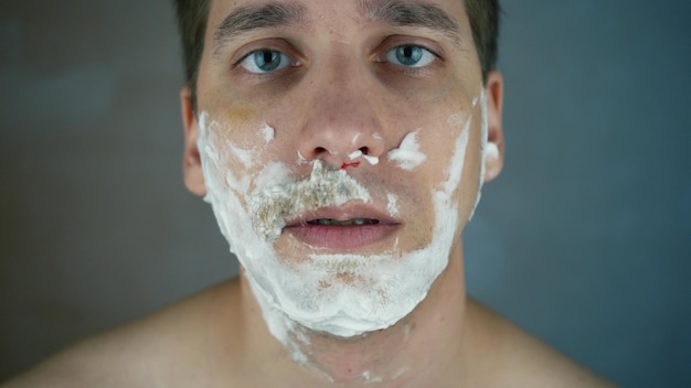 Cut after shaving on the face Irritated facial skin after daily shaving with a sharp razor a man conducts a morning procedure for shaving his beard and mustache