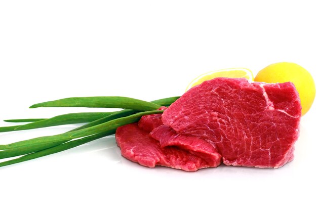 Cut of  beef steak with lemon slice and onion. Isolated.