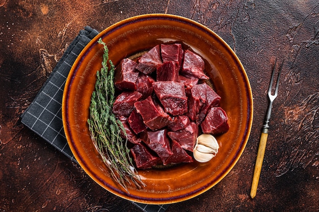 Cut Beef or veal raw heart in a rustic plate with herbs