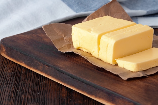 Cut butter on plate with blue towel on kitchen table