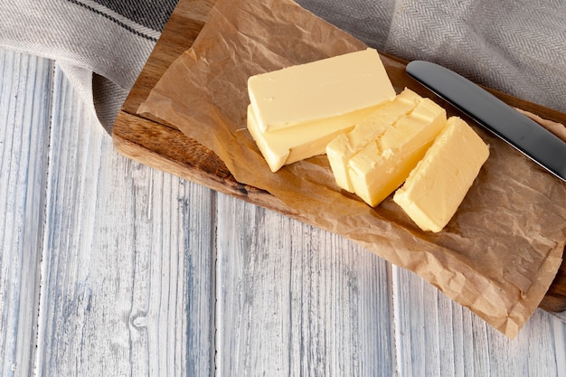 Cut butter on plate with blue towel on kitchen table