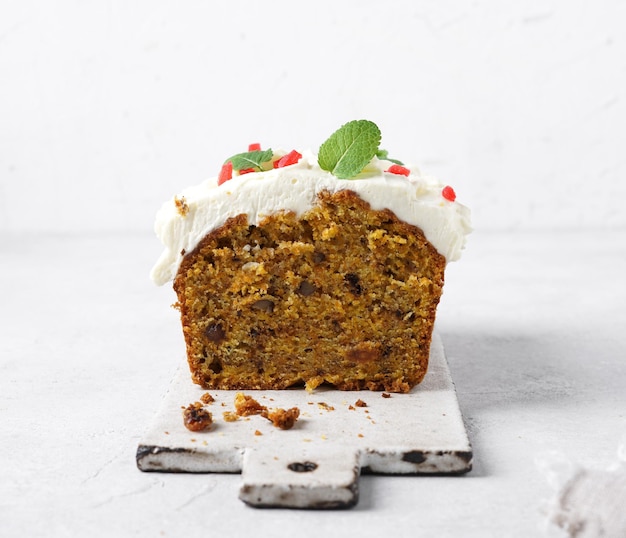 Cut of carrot cake with white icing on a plate