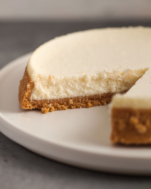 Foto tagli il primo piano della torta della torta di formaggio su un piatto bianco