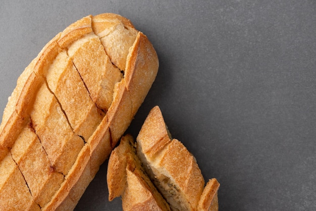 Cut French bread on grey background