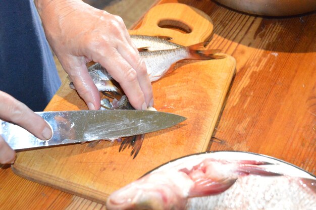 Photo cut fresh river fish with a knife