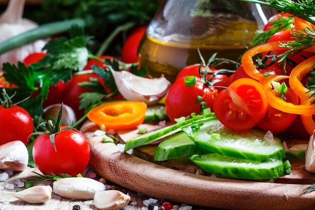 Foto tagliare le spezie delle verdure fresche e l'olio d'oliva per un fuoco selettivo di cibo sano per un'insalata di primavera