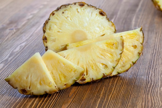 Cut into pieces ripe yellow pineapple on the table