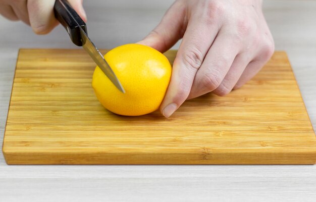 Cut the lemon.Men's hands slice a lemon.