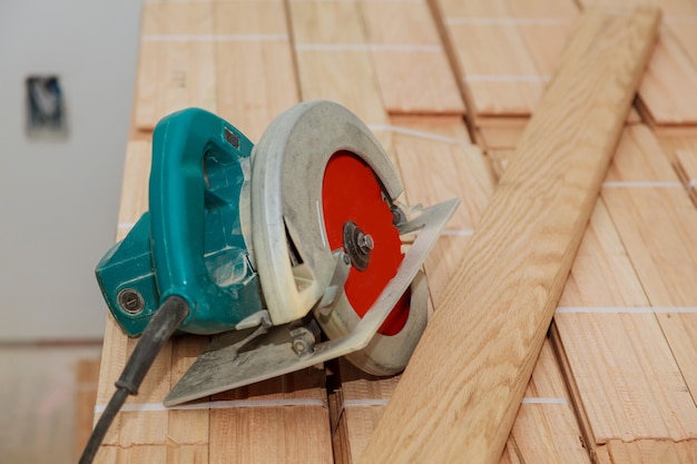 Cut old parquet floor with electric saw