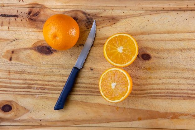 A cut orange on the table next to a knife