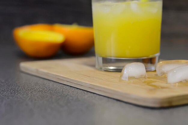 写真 木製のテーブルの上に横たわっているオレンジをカットします。朝食のフルーツカット。新鮮なジュース。オレンジジュース。
