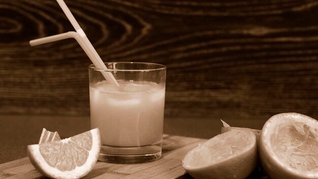 Foto tagliare le arance sdraiate su un tavolo di legno. tagliata di frutta per colazione. succo fresco. succo d'arancia. poster in bianco e nero.